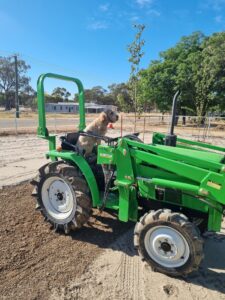 KooeeKeis Maddie Cameron sitting on a green tractor